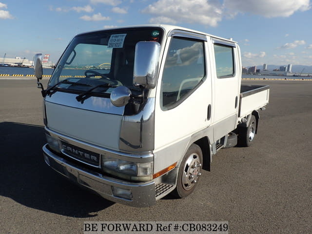 A grey sports car speeding down a highway at night.