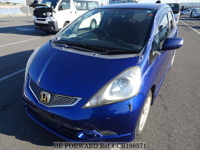 A grey JDM sports car speeding down a highway at night.