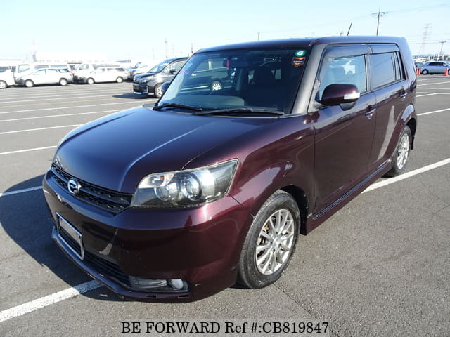 A grey JDM sports car speeding down a highway at night.