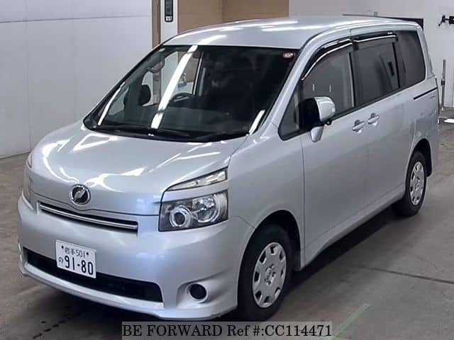 A grey sports car speeding down a highway at night.