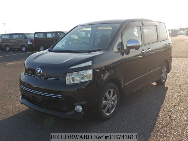 A grey JDM sports car speeding down a highway at night.
