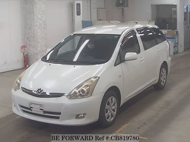 A grey JDM sports car speeding down a highway at night.