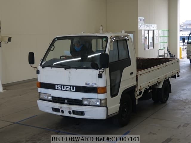 A grey sports car speeding down a highway at night.