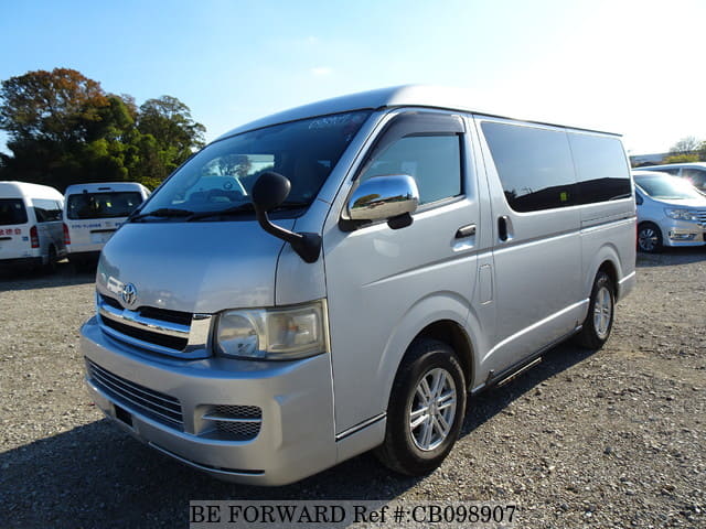 A grey sports car speeding down a highway at night.