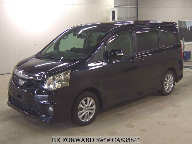A grey JDM sports car speeding down a highway at night.