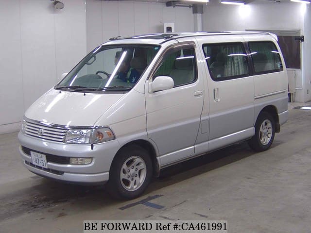 A grey JDM sports car speeding down a highway at night.