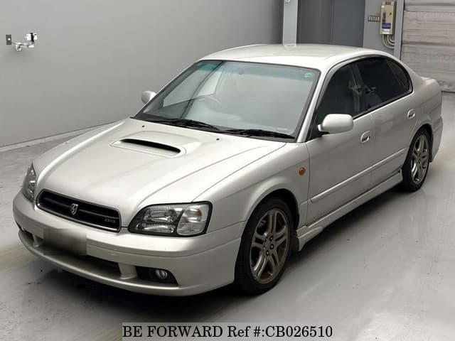 A grey JDM sports car speeding down a highway at night.