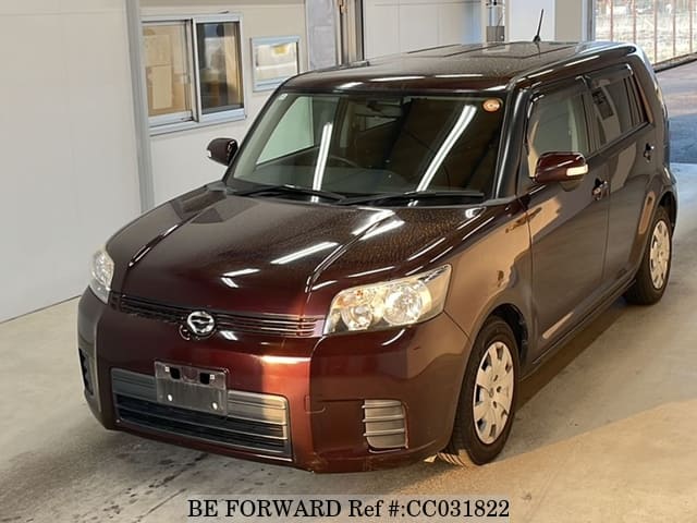 A grey sports car speeding down a highway at night.