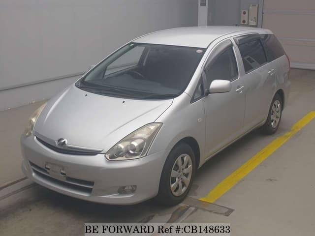 A grey JDM sports car speeding down a highway at night.
