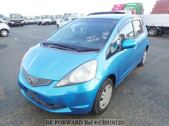 A grey sports car speeding down a highway at night.
