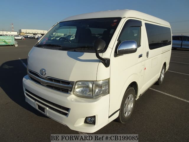 A grey sports car speeding down a highway at night.
