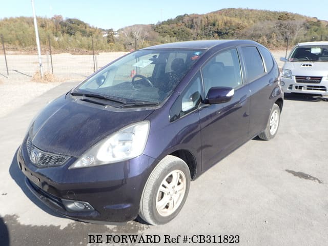 A grey JDM sports car speeding down a highway at night.