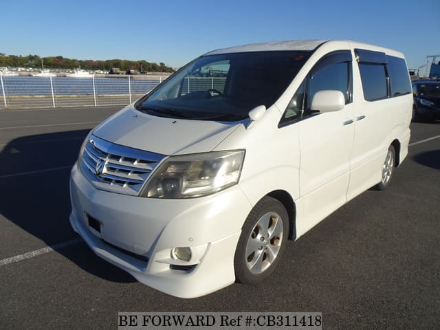 A grey JDM sports car speeding down a highway at night.