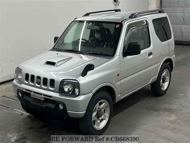 A grey JDM sports car speeding down a highway at night.