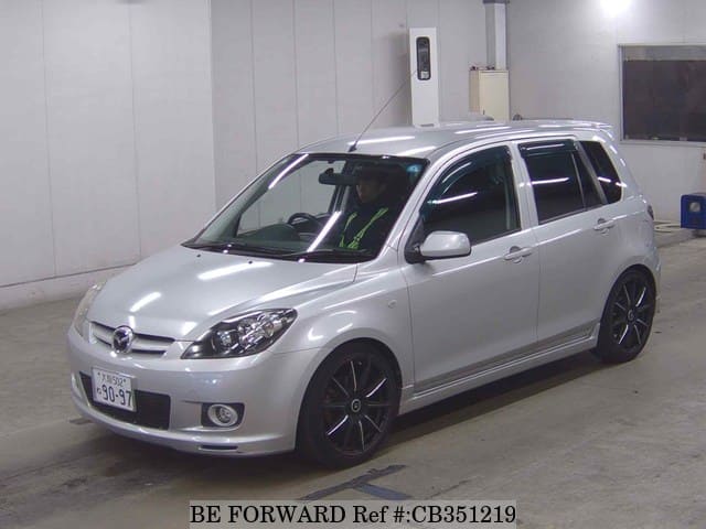 A grey JDM sports car speeding down a highway at night.