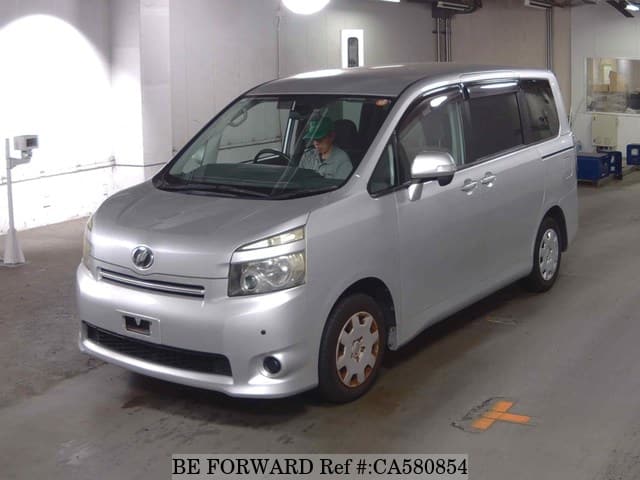 A grey JDM sports car speeding down a highway at night.