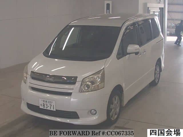 A grey sports car speeding down a highway at night.