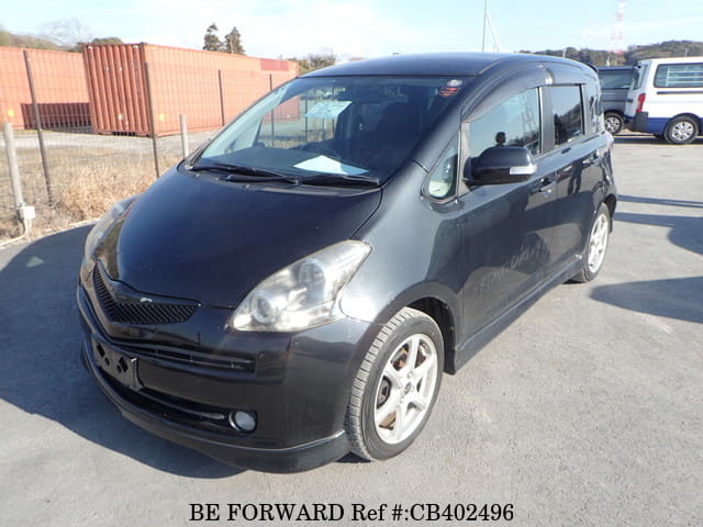 A grey JDM sports car speeding down a highway at night.
