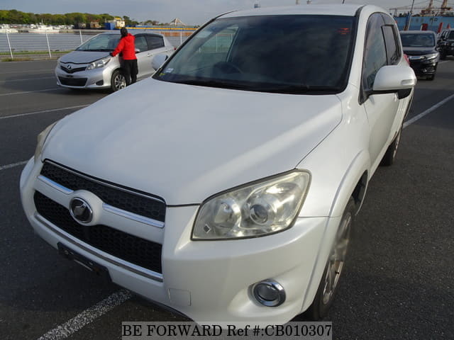 A grey JDM sports car speeding down a highway at night.