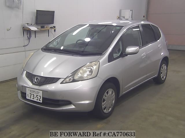 A grey JDM sports car speeding down a highway at night.