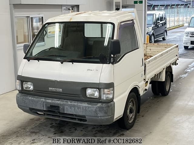 A grey sports car speeding down a highway at night.