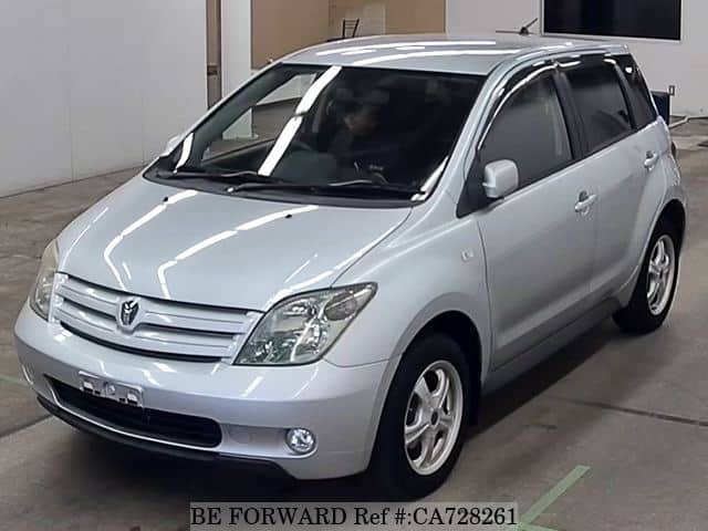 A grey JDM sports car speeding down a highway at night.