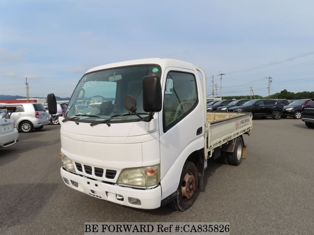A grey JDM sports car speeding down a highway at night.