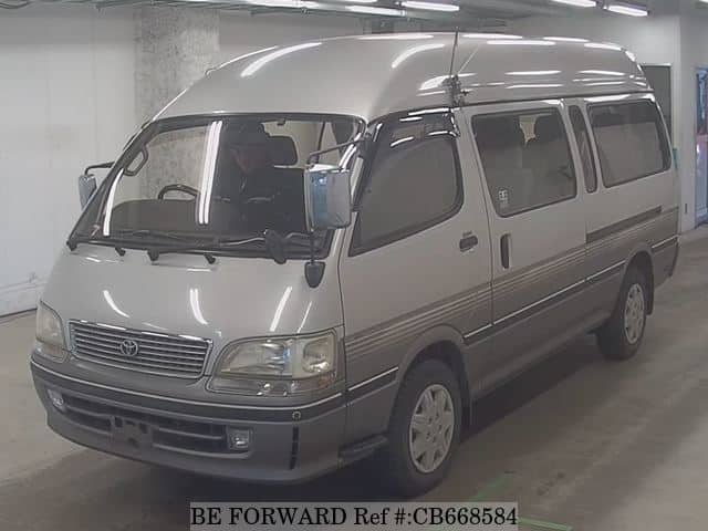 A grey sports car speeding down a highway at night.