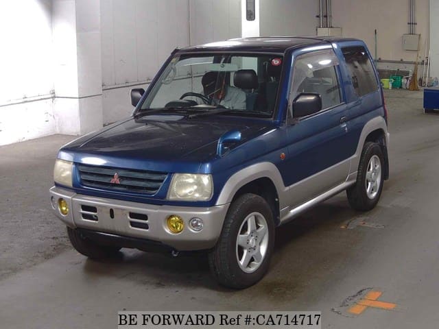 A grey JDM sports car speeding down a highway at night.