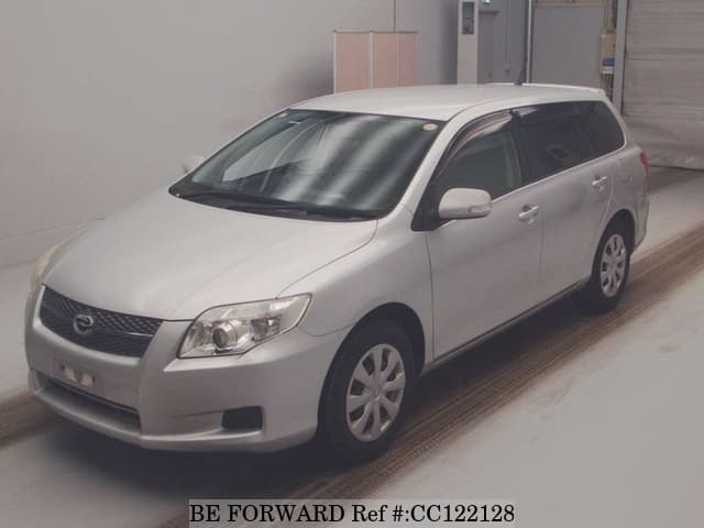A grey sports car speeding down a highway at night.