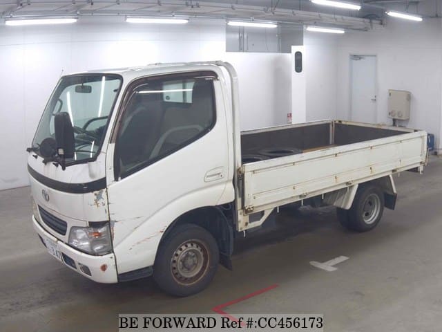 A grey JDM sports car speeding down a highway at night.