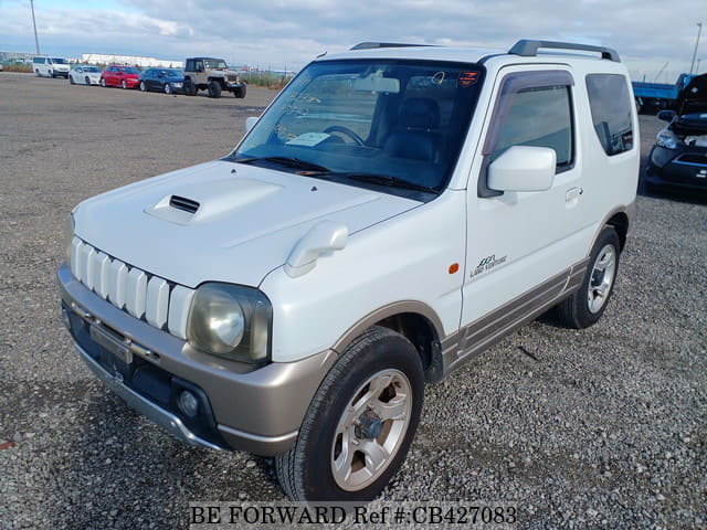 A grey JDM sports car speeding down a highway at night.