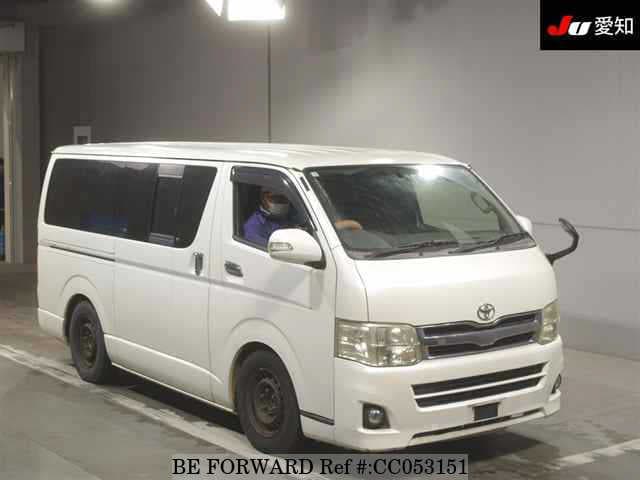 A grey sports car speeding down a highway at night.