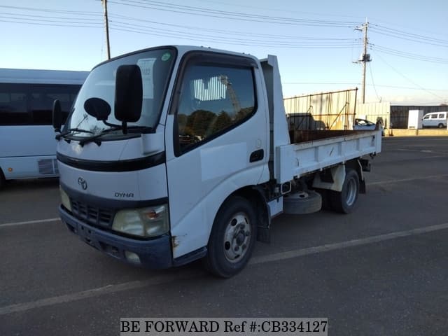A grey JDM sports car speeding down a highway at night.