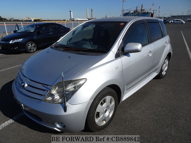 A grey JDM sports car speeding down a highway at night.