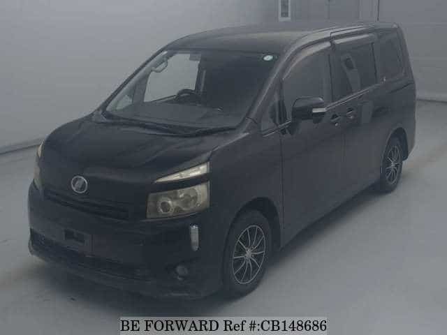 A grey JDM sports car speeding down a highway at night.