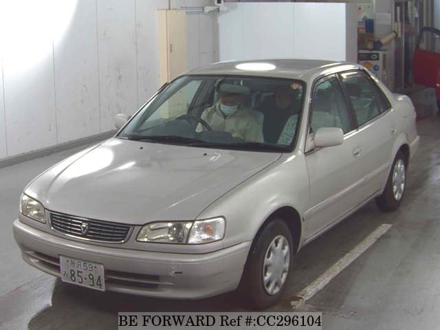A grey sports car speeding down a highway at night.