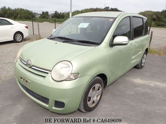 A grey JDM sports car speeding down a highway at night.