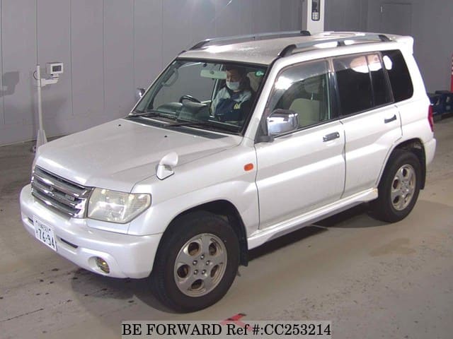 A grey sports car speeding down a highway at night.