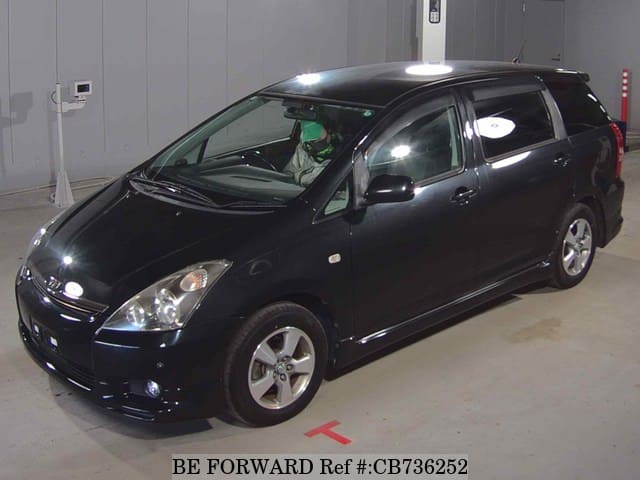 A grey JDM sports car speeding down a highway at night.