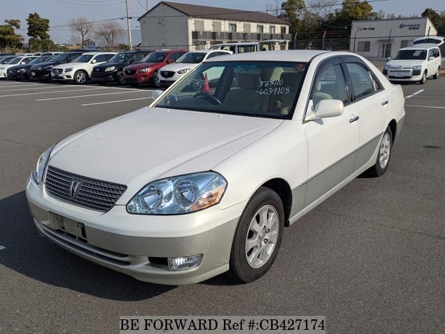 A grey JDM sports car speeding down a highway at night.