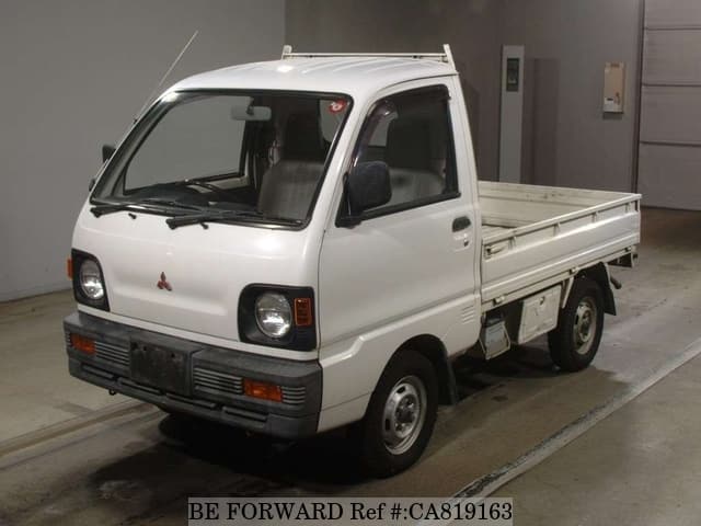 A grey JDM sports car speeding down a highway at night.