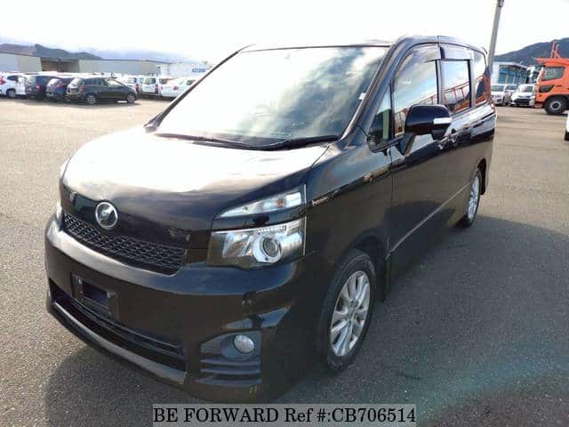 A grey JDM sports car speeding down a highway at night.