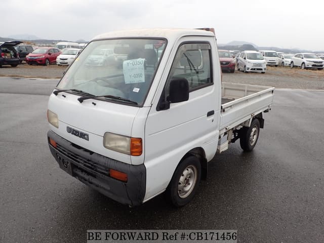 A grey JDM sports car speeding down a highway at night.