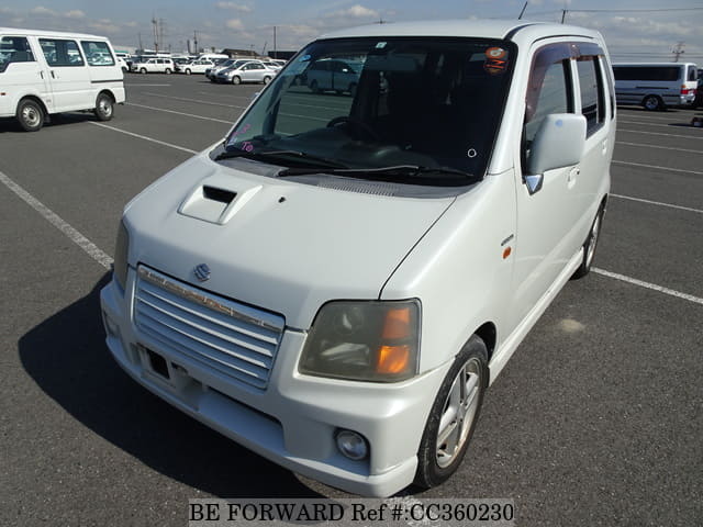 A grey sports car speeding down a highway at night.