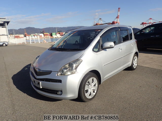 A grey JDM sports car speeding down a highway at night.