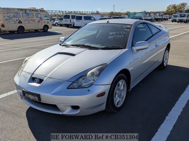 A grey JDM sports car speeding down a highway at night.