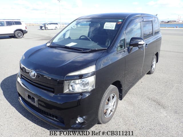 A grey JDM sports car speeding down a highway at night.