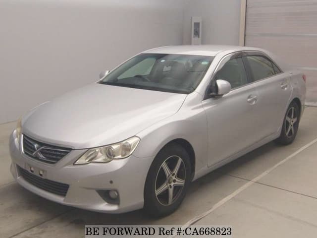 A grey JDM sports car speeding down a highway at night.