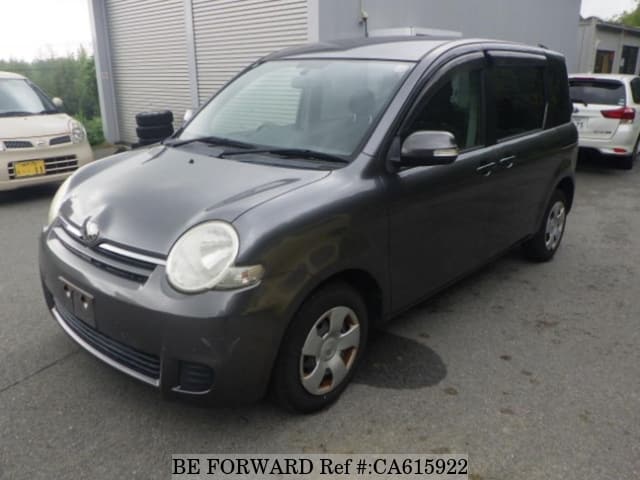 A grey JDM sports car speeding down a highway at night.